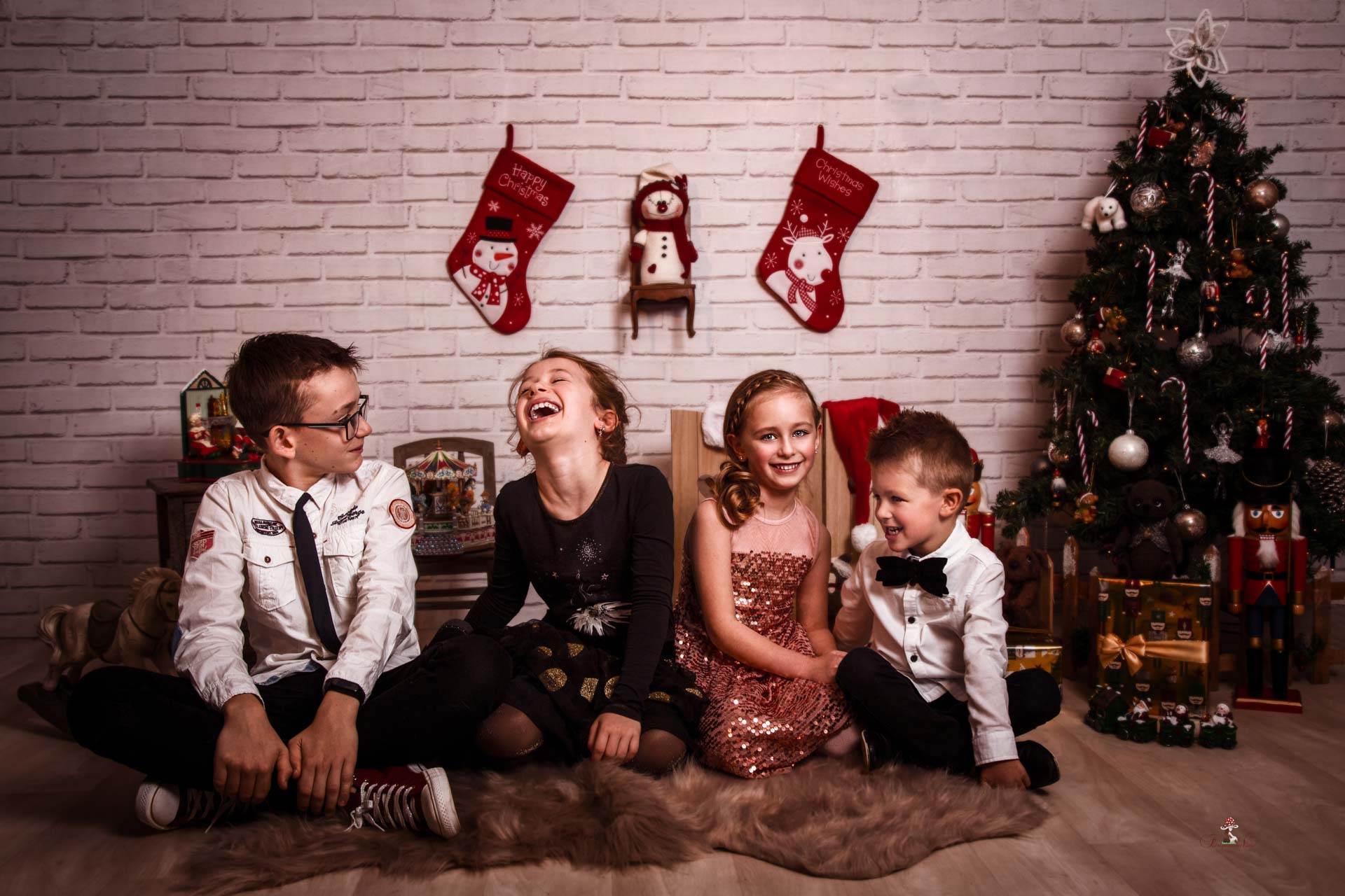 Des enfants assis dans un décor de Noël qui discutent et rient