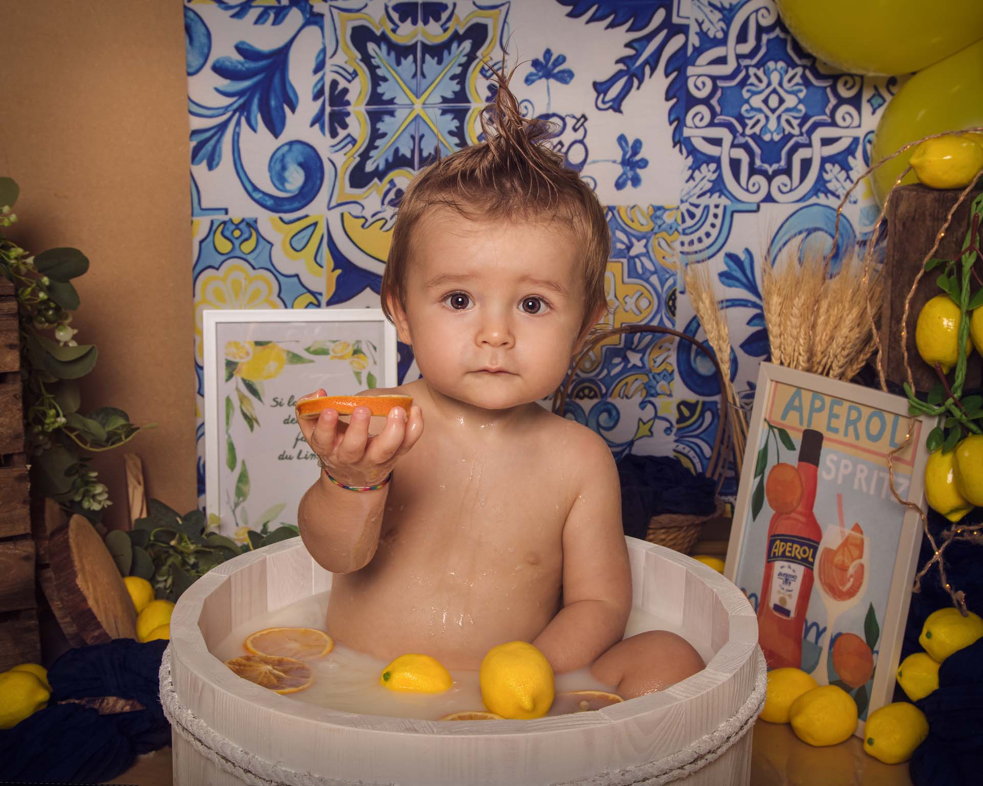 Le garçon dans son bain de lait, avec des oranges.